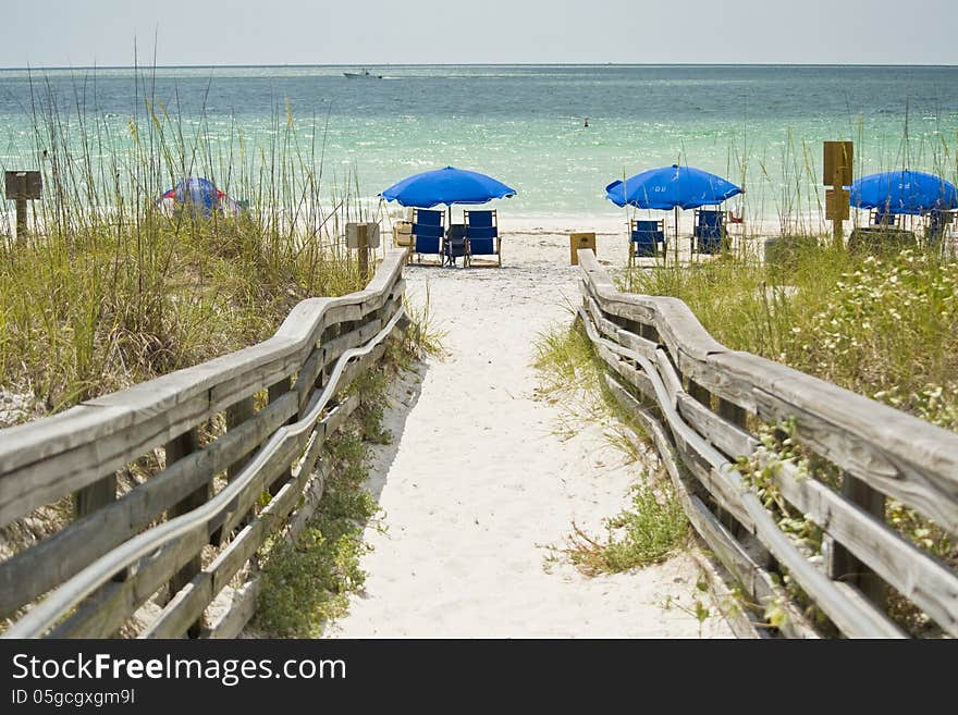 Wooden walkway goes out of a beach.