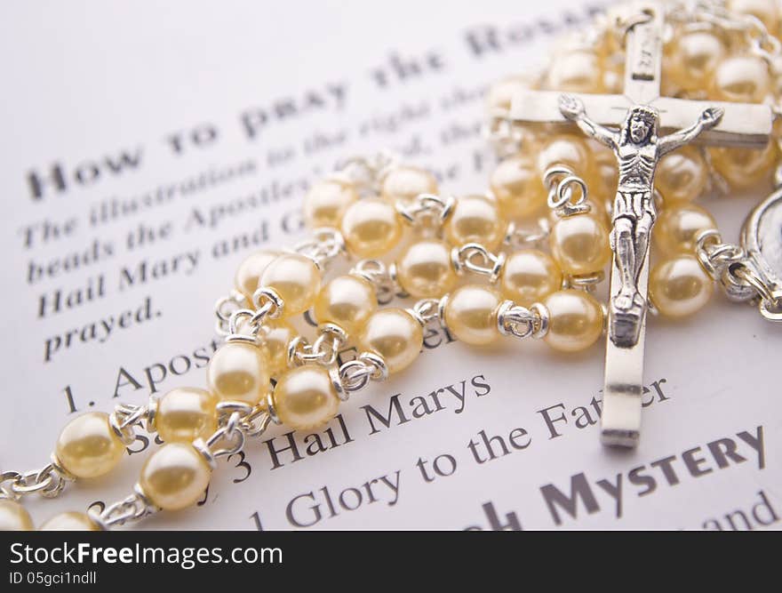 Closeup of a rosary on instructions. Closeup of a rosary on instructions.