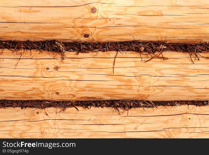 Wooden loggs wall background filled by moss in joints. Wooden loggs wall background filled by moss in joints