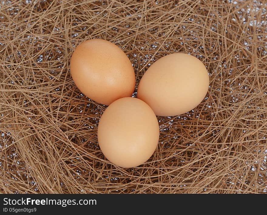 Three eggs on hay nest background. Three eggs on hay nest background