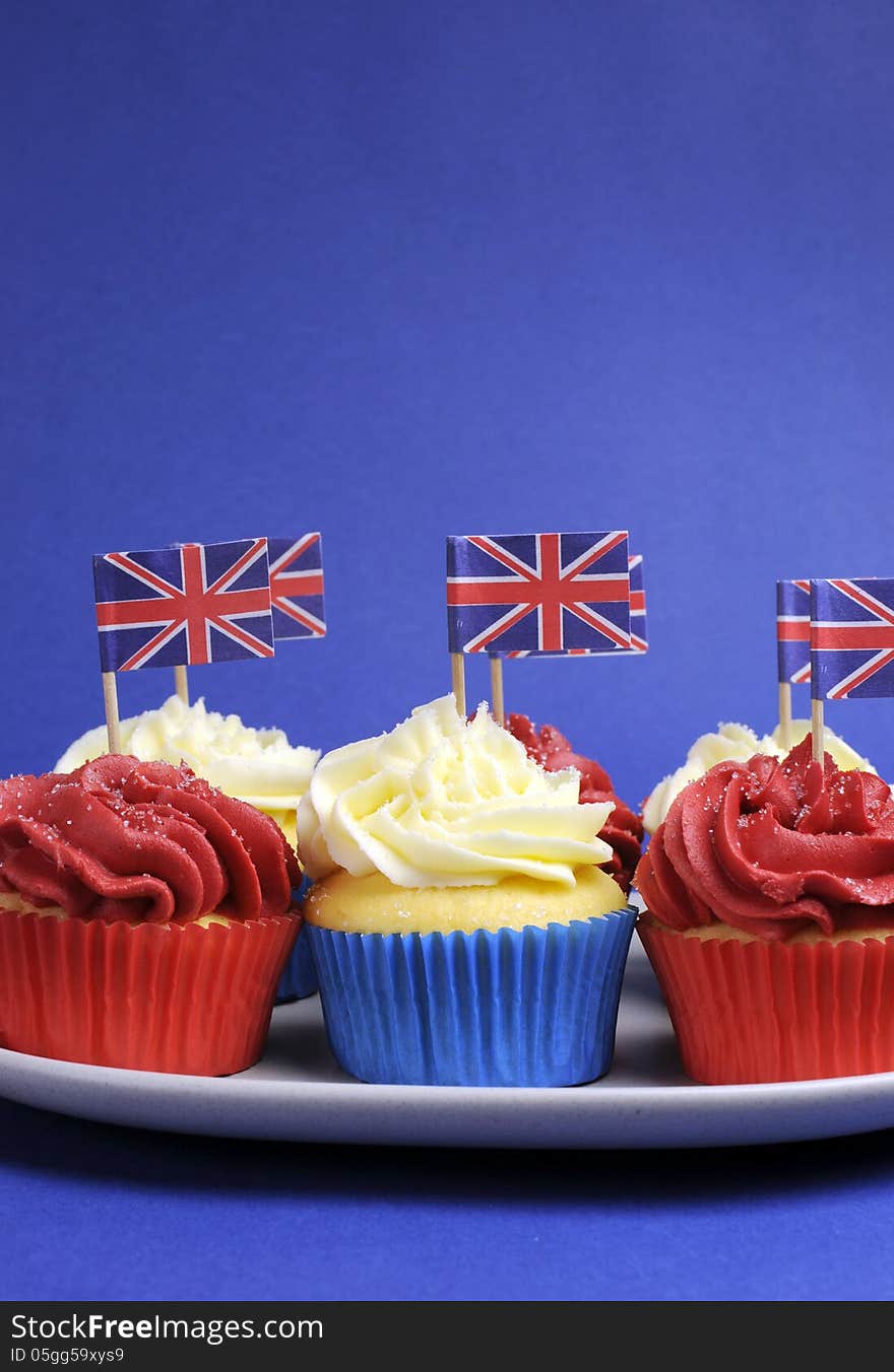 English theme red, white and blue cupcakes with Great Britain Union Jack flags - vertical with copy space.