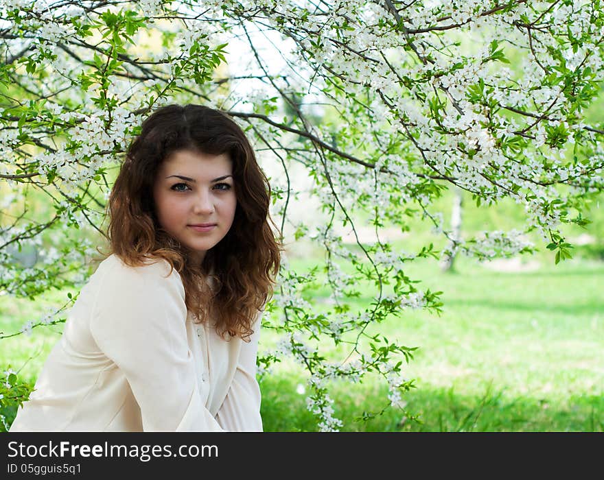 Portrait of young brunette in the spring garden. Portrait of young brunette in the spring garden