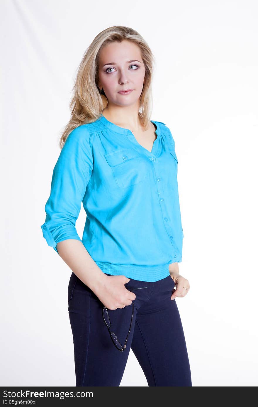 Beautiful blonde in a blue blouse and pants rehearsing a photo shoot. Beautiful blonde in a blue blouse and pants rehearsing a photo shoot