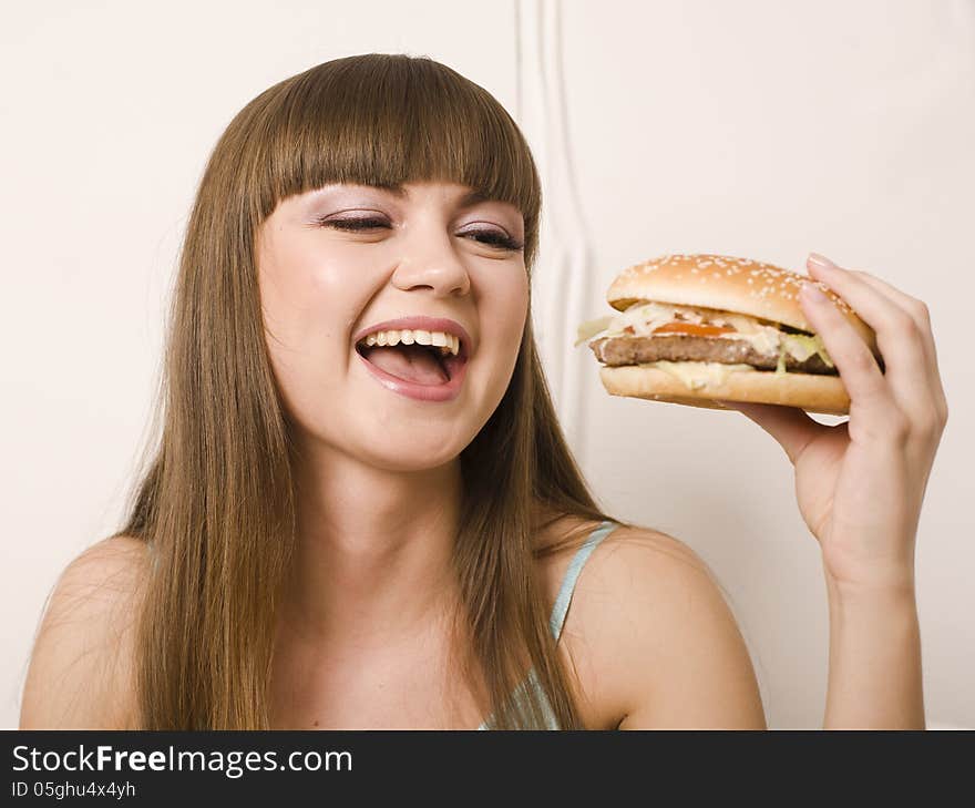 Portrait of young pretty woman with burger on white background