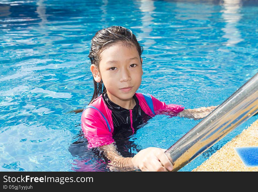 Girl relaxing on the side of a swimming pool. Girl relaxing on the side of a swimming pool