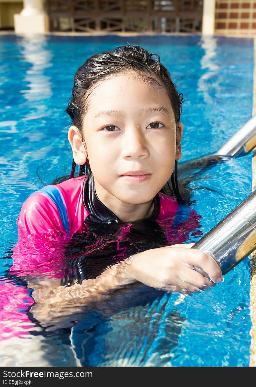 Girl relaxing on the side of a swimming pool. Girl relaxing on the side of a swimming pool