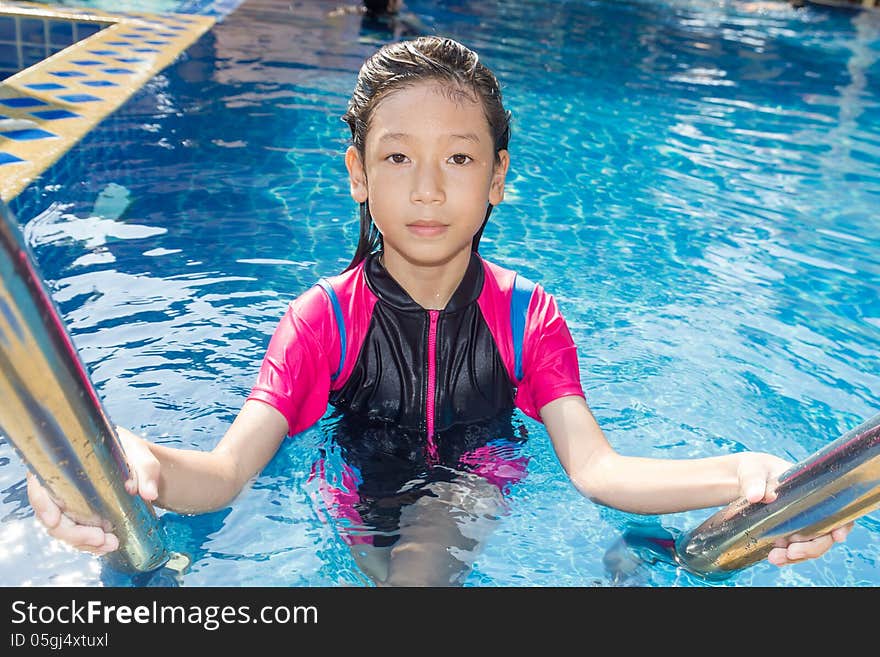 Girl relaxing on the side of a swimming pool. Girl relaxing on the side of a swimming pool