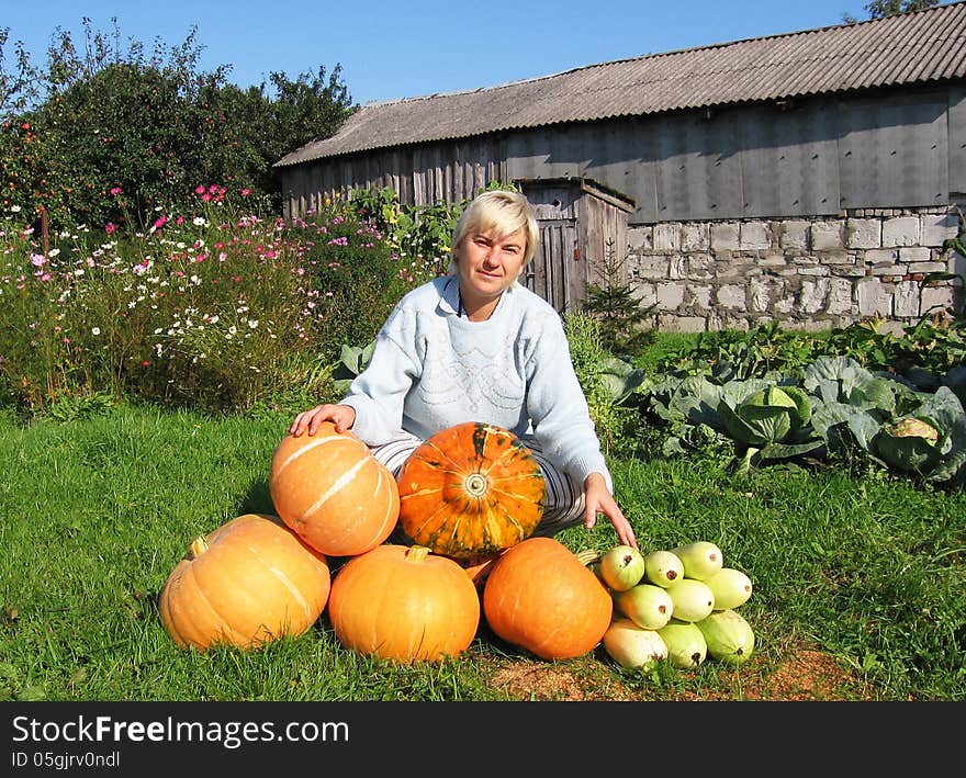 Woman with a crop of pumpkins and squash on her farm