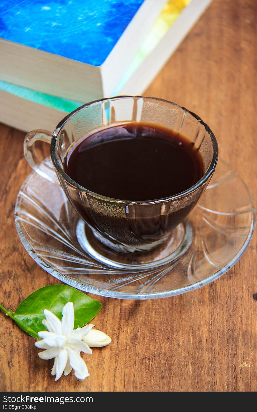 Black coffee on wooden table with old books and Jasmine flower. Black coffee on wooden table with old books and Jasmine flower