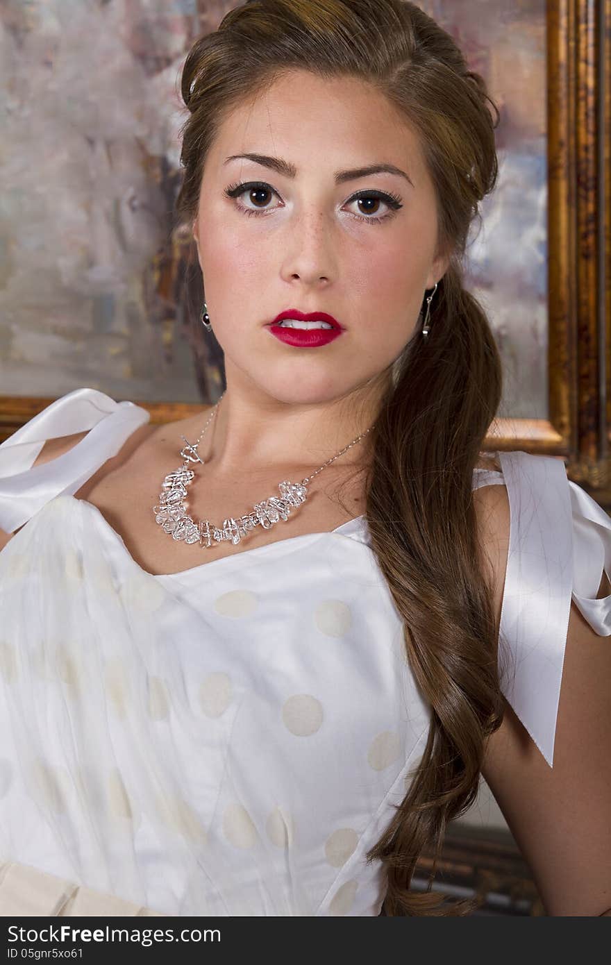 Young attractive woman wearing a necklace, bracelet and a satin bridal designer gown. Young attractive woman wearing a necklace, bracelet and a satin bridal designer gown