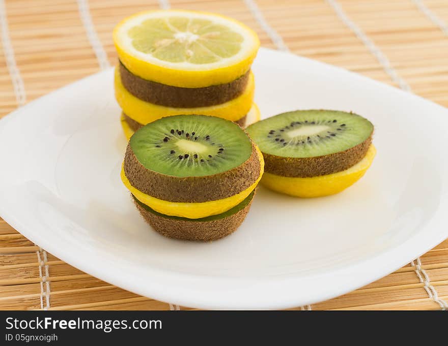 Mixed fruits on white dish at bamboo background