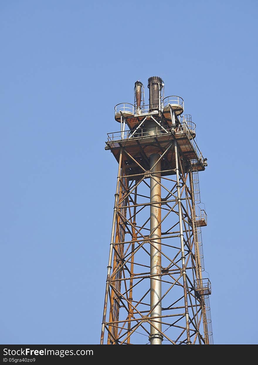 Top of distillation tower in blue sky and sunlight