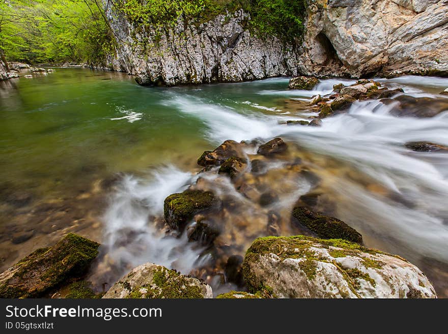 Mountain stream and waterfalls in the forest in spring