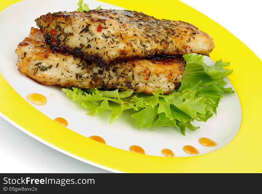 Slices of Roasted Chicken Fillet with Herbs, Lettuce and Honey Sauce on Yellow Plate closeup