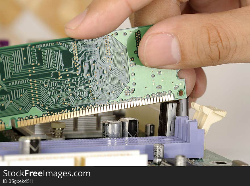 Man hand install memory card board on the computer motherboard