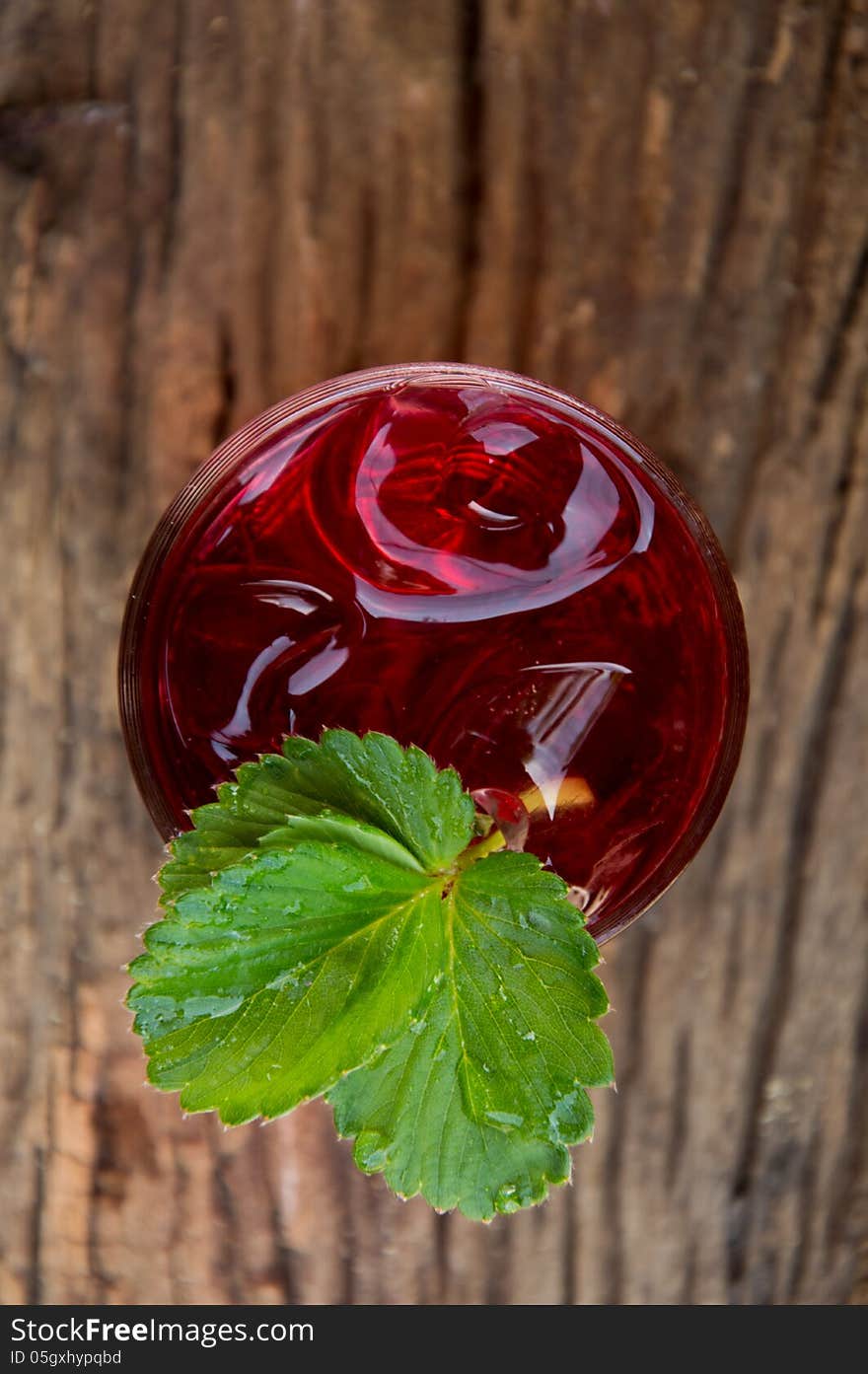 Strawberry juice and leaves on wood. Strawberry juice and leaves on wood