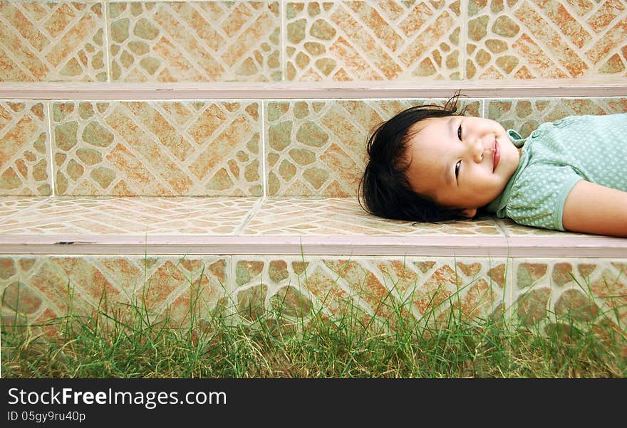 Laying smile kid on a stairway