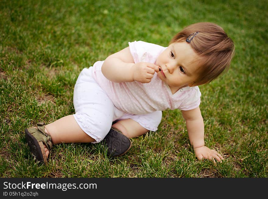 Portrait of beautiful baby girl on the lawn