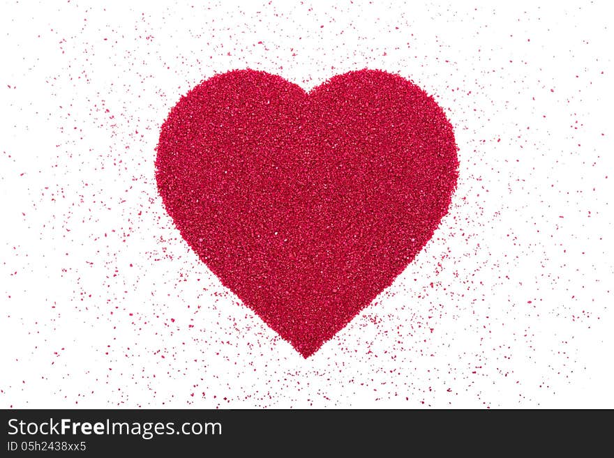 Heart made of decorative red sand is on a white background. Heart made of decorative red sand is on a white background.