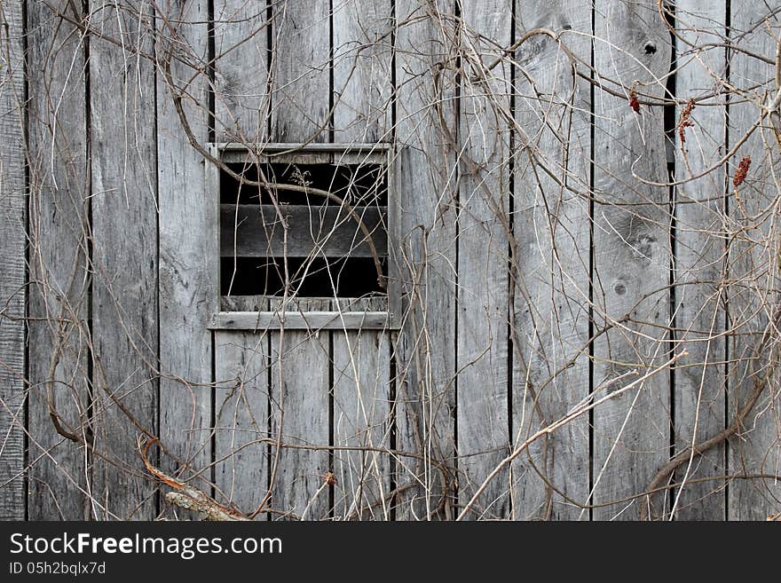 Abandoned barn with a broken window beckons the viewer to wonder what lies within. Port Sanilac Historical Village. Port Sanilac, Michigan.