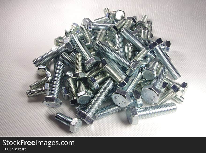 The photograph shows metal screws on a white background. The photograph shows metal screws on a white background.