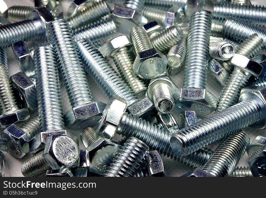 The photograph shows metal screws scattered on the ground. The photograph shows metal screws scattered on the ground.