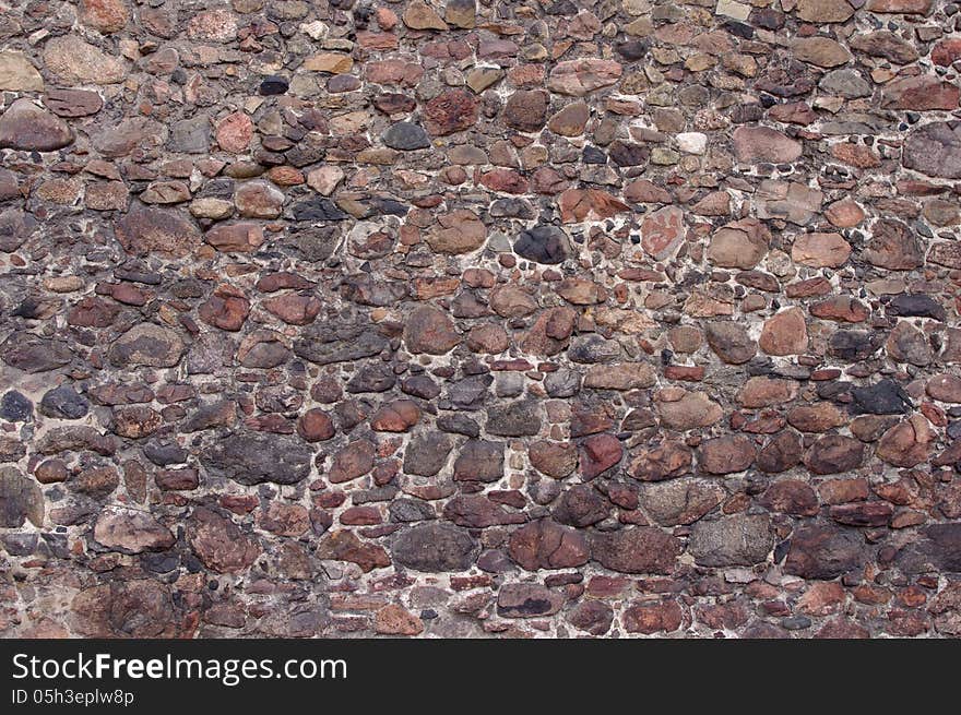 The photograph shows a fragment of an old, old wall made ​​of stones. The photograph shows a fragment of an old, old wall made ​​of stones.