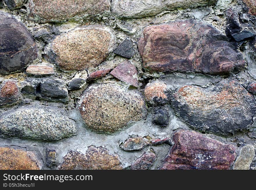 The photograph shows a fragment of an old, old wall made ​​of stones. The photograph shows a fragment of an old, old wall made ​​of stones.