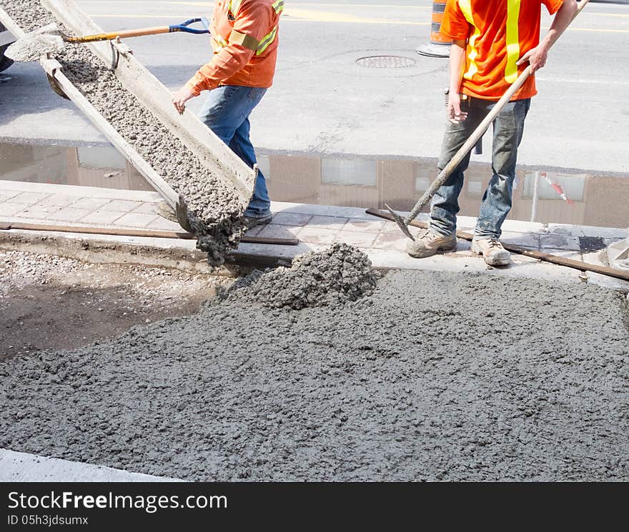 Pouring cement during sidewalk upgrade . Pouring cement during sidewalk upgrade .