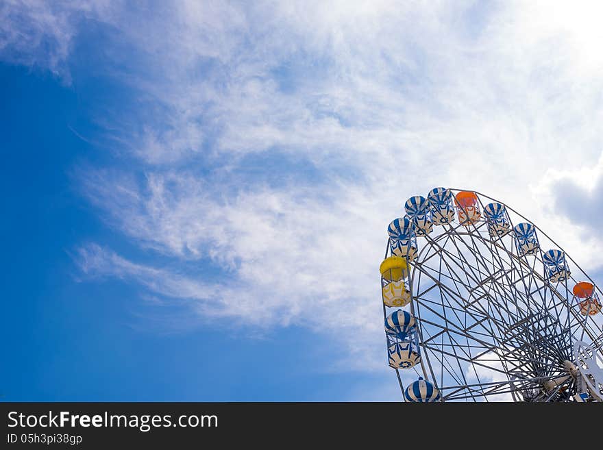 Part of ferris wheel with clear blue sky