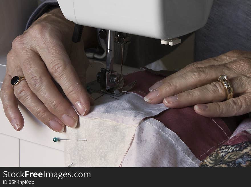 Womans hands at the sewing machine. Womans hands at the sewing machine