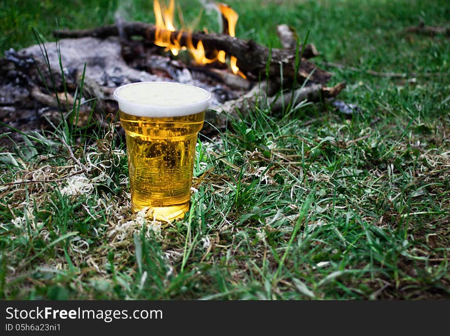 Beer with fire in nature, fresh product and good mood.