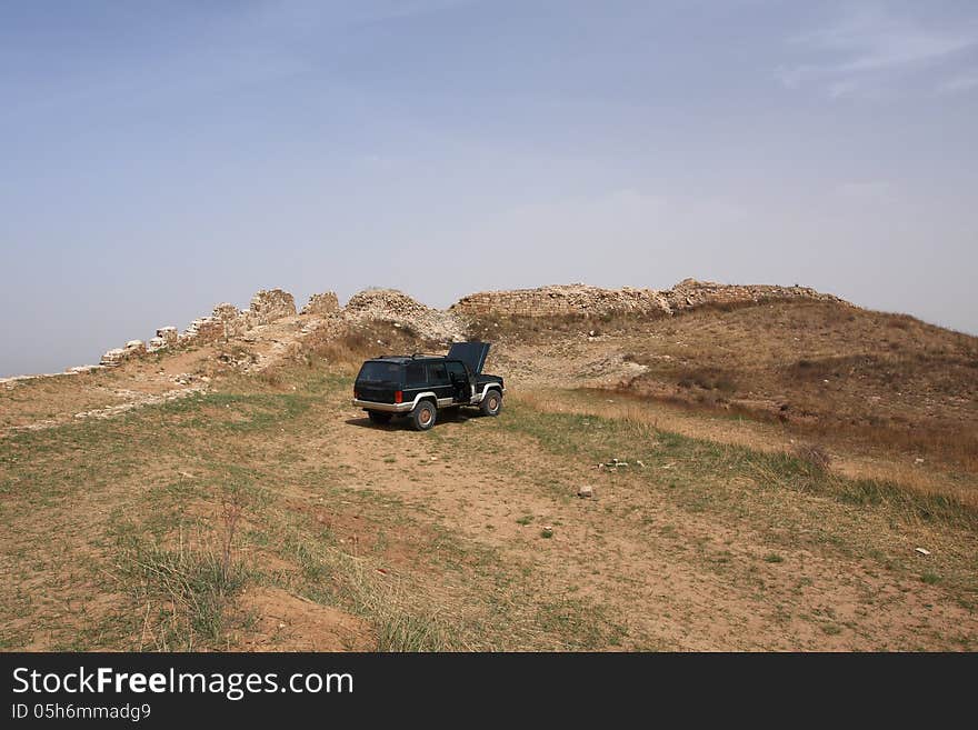 An old Jeep at the foot of the Great Wall of China