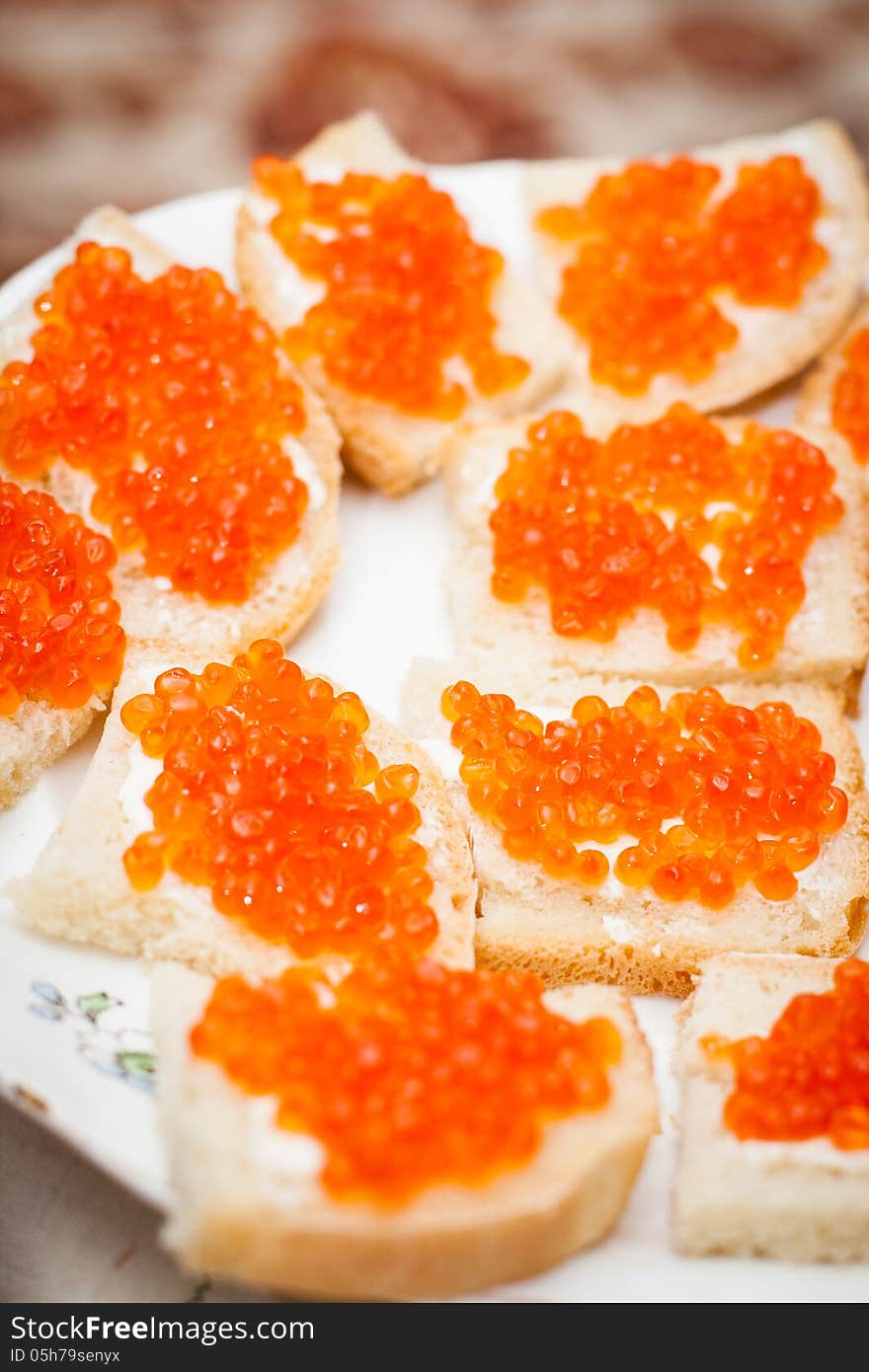 Small sandwiches with red caviar on a plate