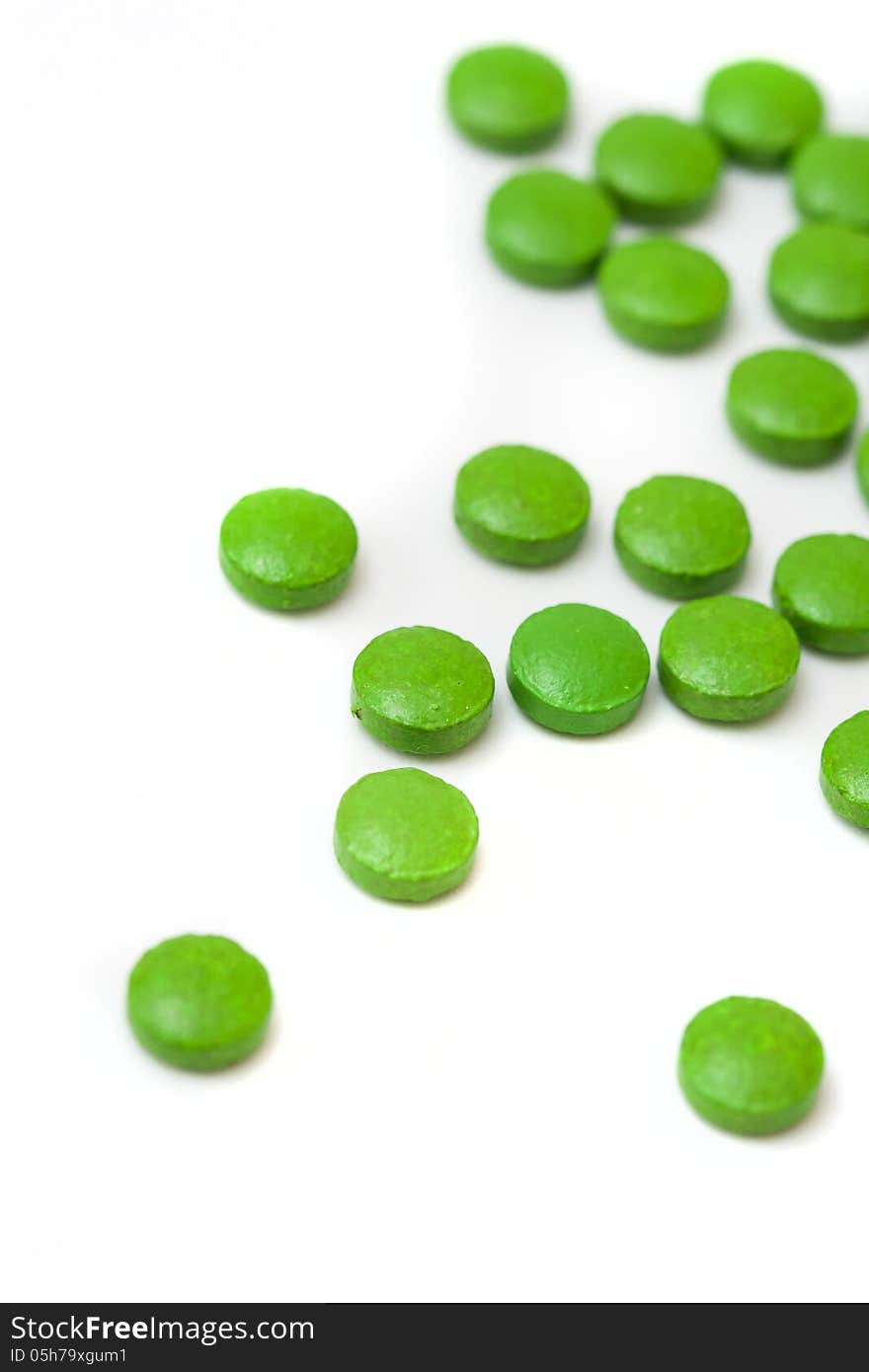 Little green pills on white background. Little green pills on white background