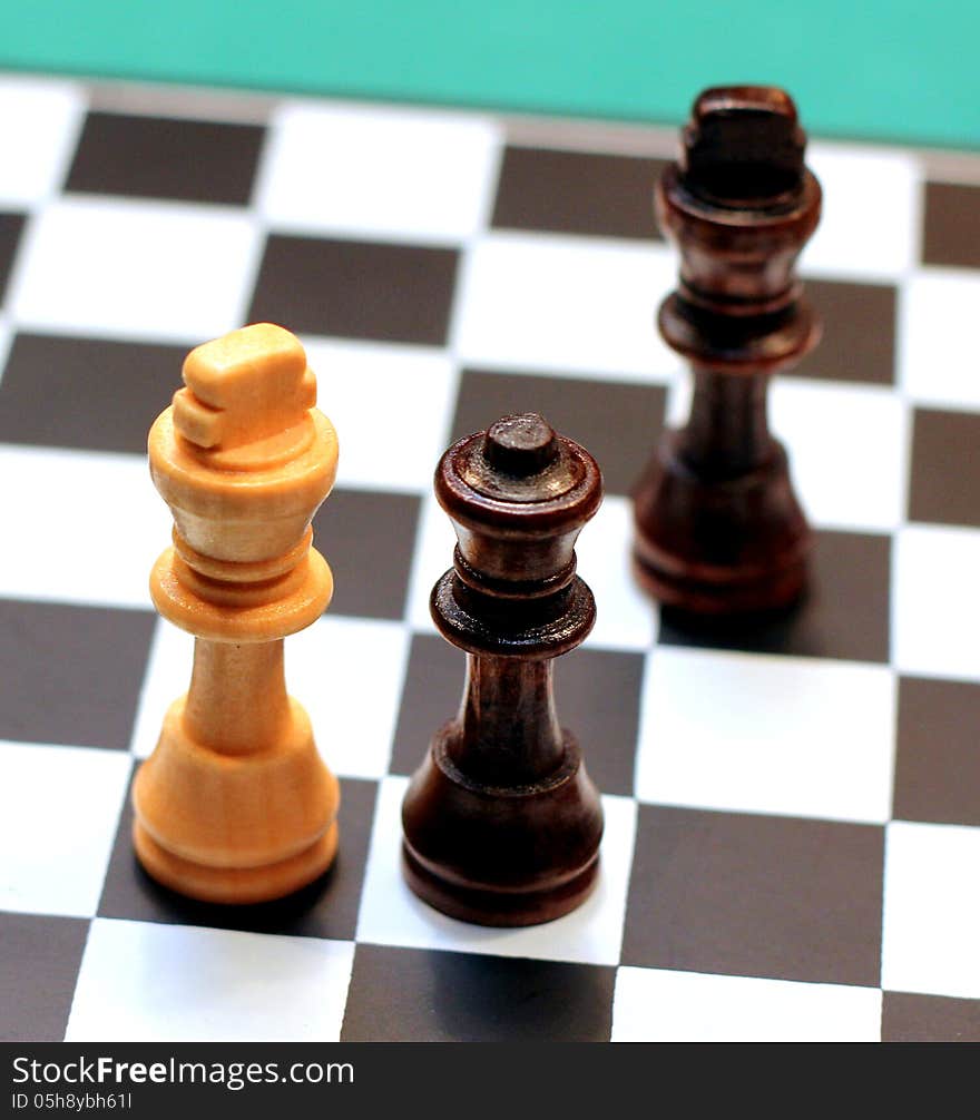 3 chess figures - queen and 2 kings. Black queen cheating!. 3 chess figures - queen and 2 kings. Black queen cheating!