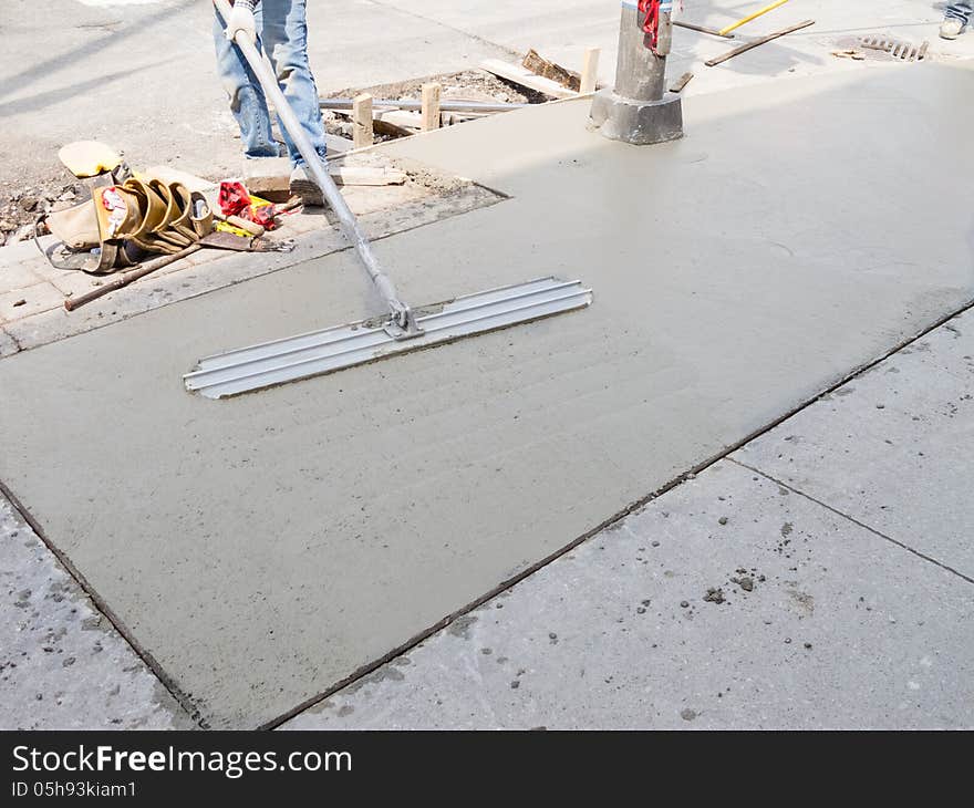 Laying down new sidewalk in urban setting. Laying down new sidewalk in urban setting