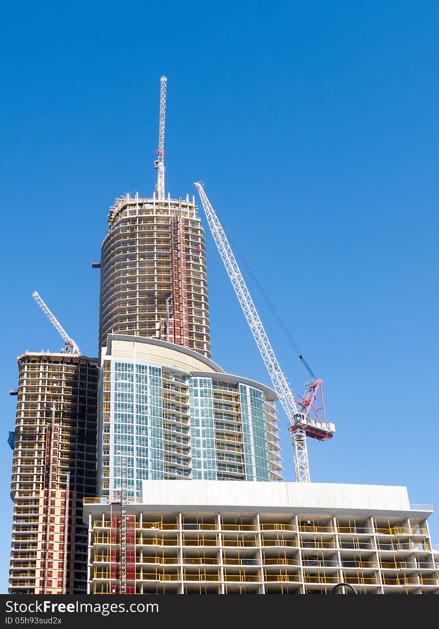 Condominium tower under construction with cranes. Condominium tower under construction with cranes