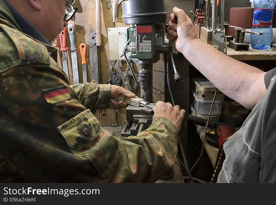 Men at work constructing a knife. Men at work constructing a knife