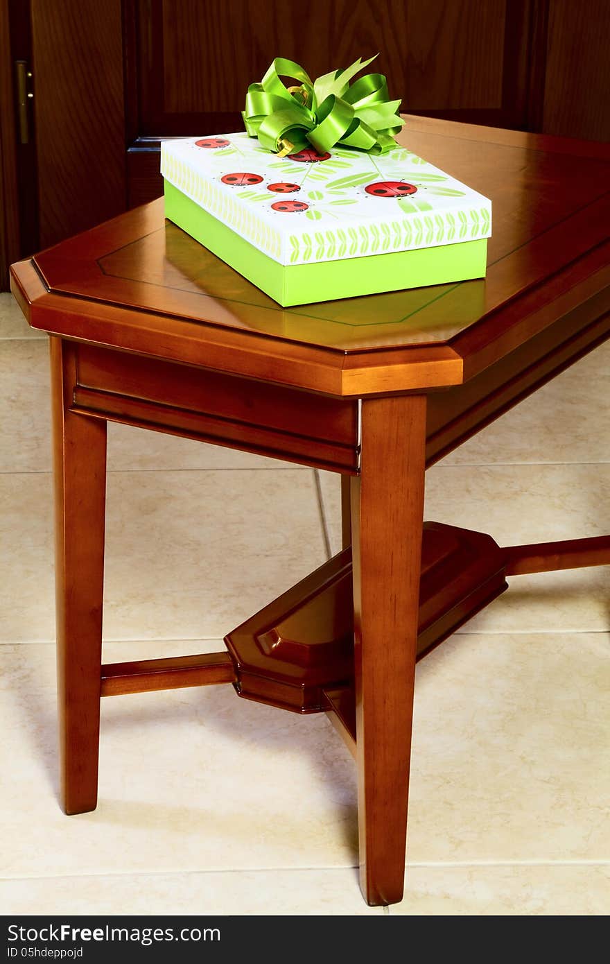 Gift in a box on the coffee table against the background of a wooden door