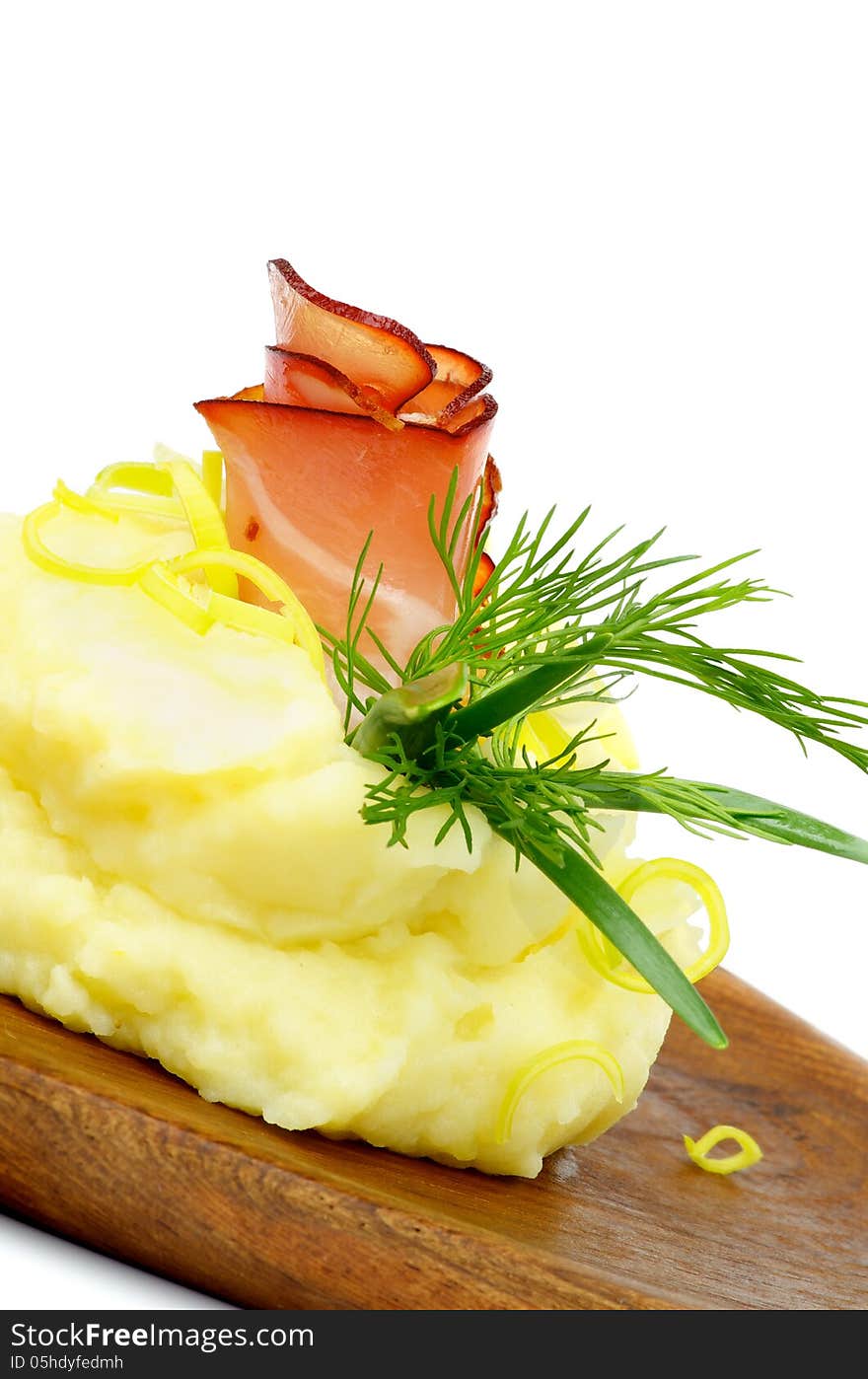 Snack of Rolled up Delicious Bacon with Mashed Potato, Dill, Spring Onion and Leek closeup on Wooden Plate. Snack of Rolled up Delicious Bacon with Mashed Potato, Dill, Spring Onion and Leek closeup on Wooden Plate