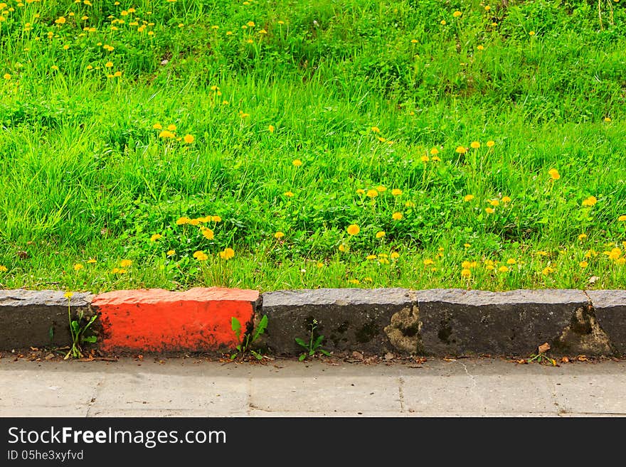 Marked by a red brick border on a green grass. Marked by a red brick border on a green grass