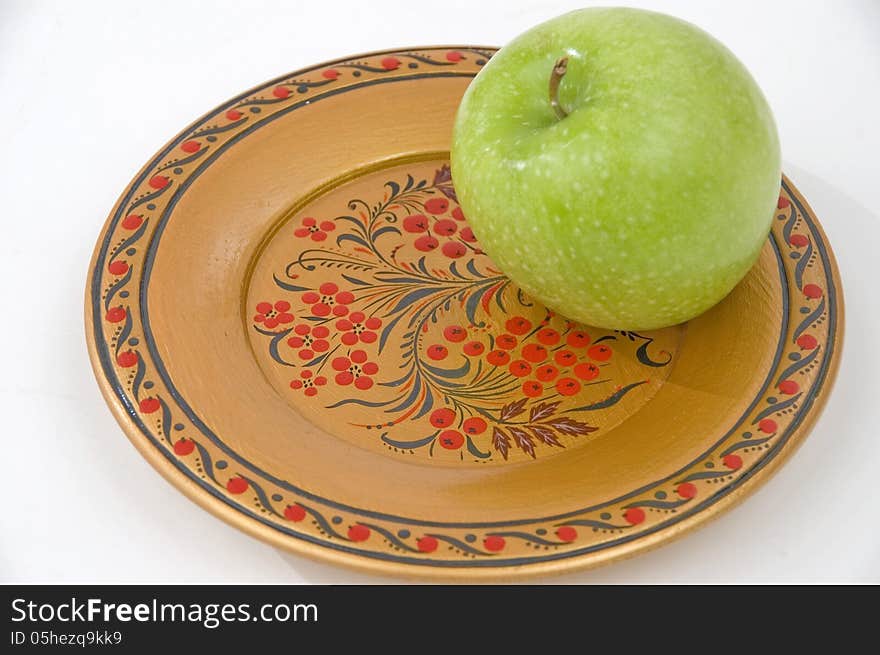 Green apple on a colour wooden plate. Green apple on a colour wooden plate.