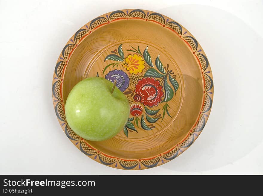 Green apple on a colour wooden plate. Green apple on a colour wooden plate.