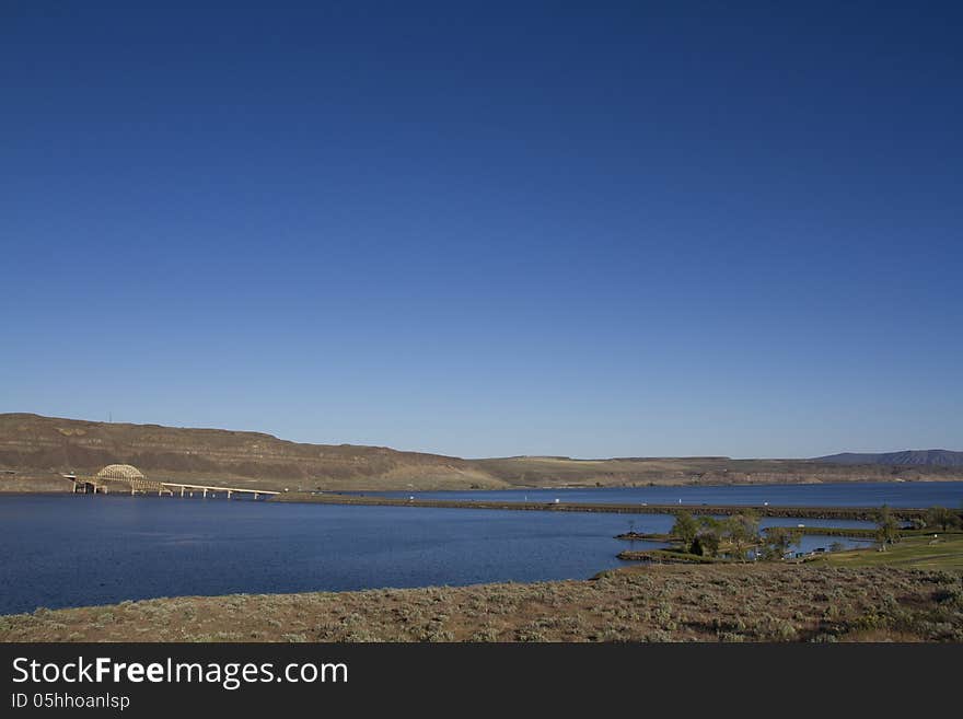 I-90 Vantage Bridge over the Columbia River Gorge in central Washington State Wide Angle with blue sky blue water rocky dry desert mountain hill Vantage