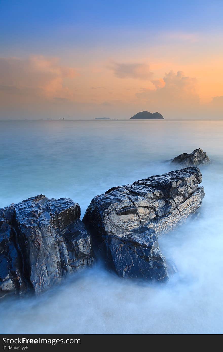 Rock on the beach with dramatic sky in Thailand