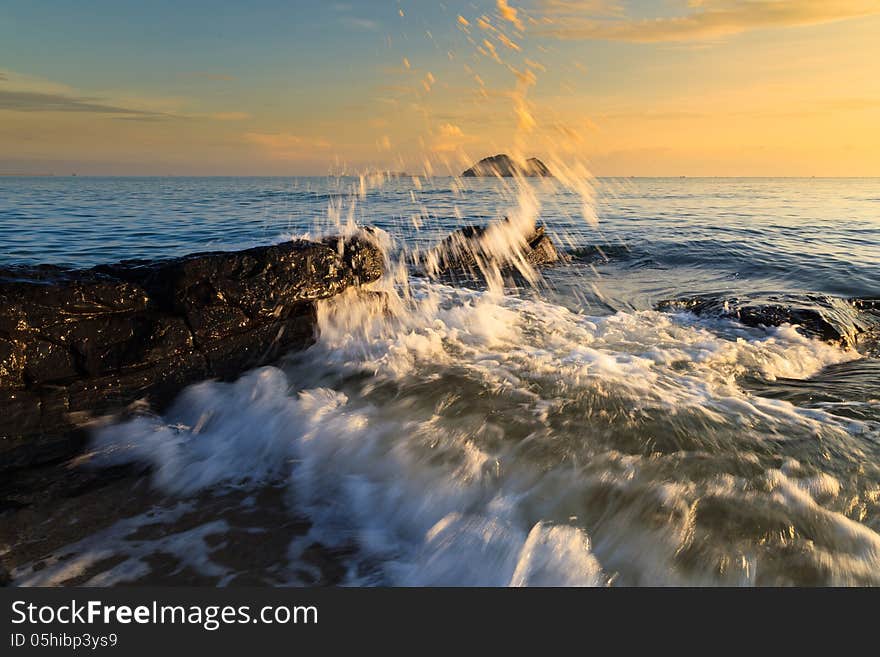 Stones and waves during sunrise in Songkha, Thailand