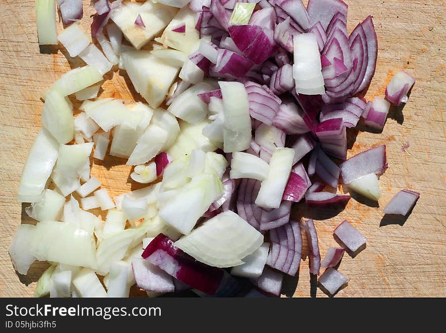 Red and white onions chopped on a wooden board ready to use. Red and white onions chopped on a wooden board ready to use.