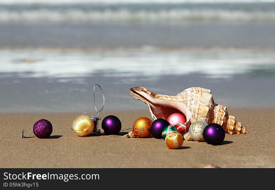 Christmas balls and seashell on the beach