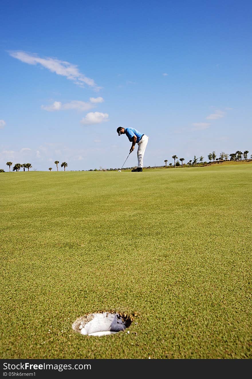 Golfer man putting on the green. Golfer man putting on the green.